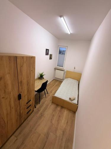 a bedroom with a bed and a desk and a door at Zamkowy Hostel Gdansk Old Town in Gdańsk
