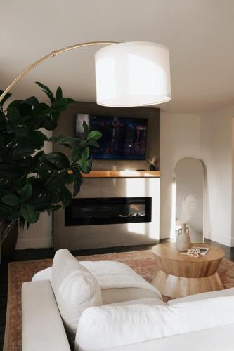 a living room with a white couch and a fireplace at Soleil House in Fort Saint John