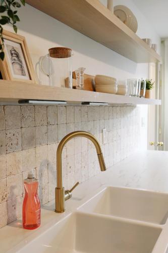 a kitchen sink with a red bottle on a counter at Soleil House in Fort Saint John