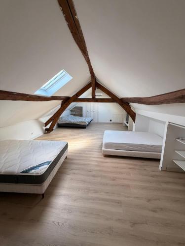 a attic bedroom with two beds and a window at Escale à Rosay in Theuville