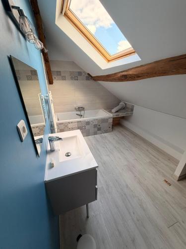 a bathroom with a sink and a skylight at Escale à Rosay in Theuville