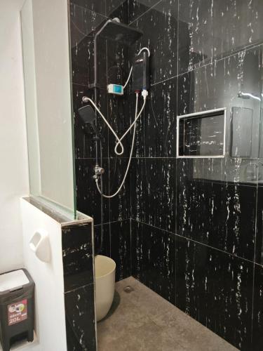 a shower in a bathroom with a black tiled wall at Seanna's Inn in San Juan