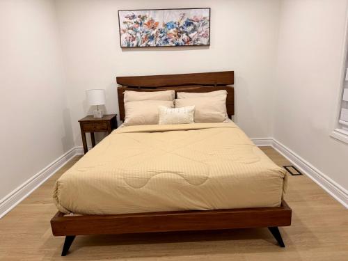 a bedroom with a large bed with a wooden frame at Bright & Cozy Home in Niagara Falls with Free Parking in Niagara Falls