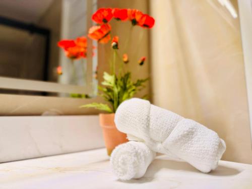a towel elephant sitting on a bathroom counter with flowers at Bright & Cozy Home in Niagara Falls with Free Parking in Niagara Falls