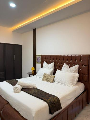 a large bed with white sheets and pillows at Samash villa foxdale 2 bedroom in Lusaka