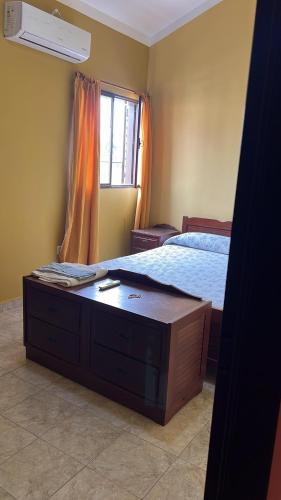 a bedroom with a bed with a dresser and a window at Tu departamento en Formosa in Formosa