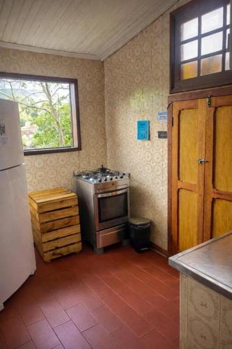 a kitchen with a stove in the corner of a room at Nuh Hostel - Quartos coletivos in Ouro Preto