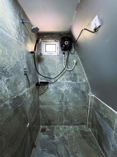 a bathroom with a shower with a hose at Sunshine Cabana and Resort in Haldummulla
