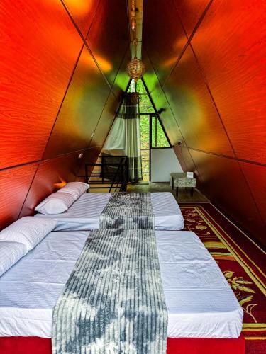 a group of beds in a room with a ceiling at Sunshine Cabana and Resort in Haldummulla