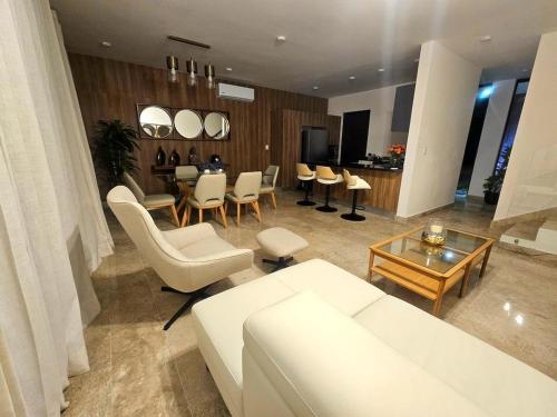 a living room with a white couch and a table at Cancún Arbolada Huayacan in Cancún