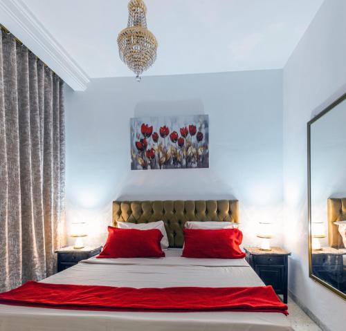 a bedroom with a large bed with red pillows at VIP Home in El Aouina Station