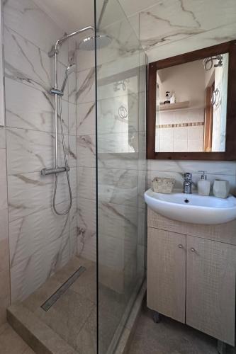 a bathroom with a glass shower and a sink at Elia Studio in Sokrákion