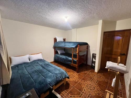 a bedroom with a bed and a bunk bed at Granja Doña Carmelita in Ibarra