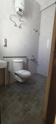 a bathroom with a white toilet and a sink at Silver Sand Resorts With Private Swimming Pool in Chennai