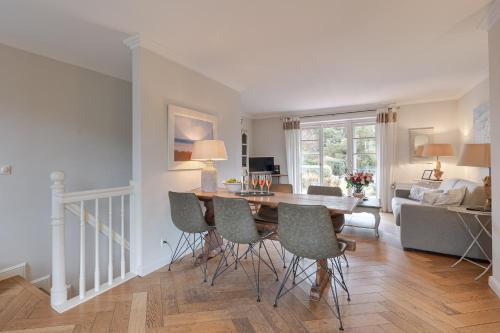 a dining room and living room with a table and chairs at Deichgraf 4 in Kampen