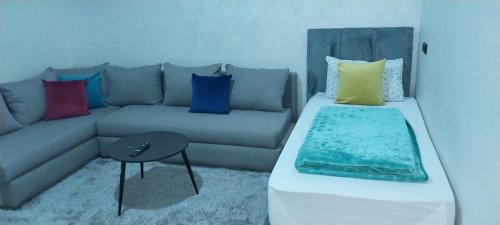 a living room with a couch with colorful pillows at rooms maissa 1 in Cabo Bojador