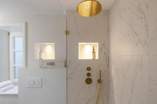 a bathroom with a shower with white marble walls at Deichgraf 4 in Kampen