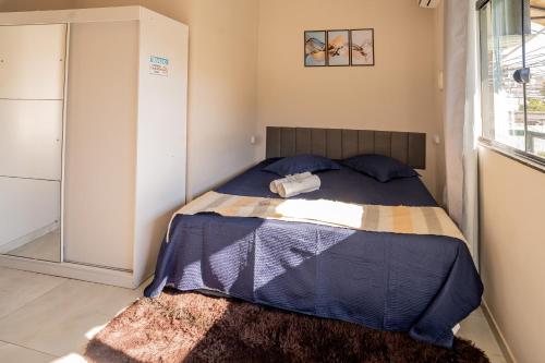 a bedroom with a bed with a blue comforter at Refúgio Black in Sabará