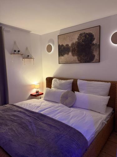 a bedroom with a large bed with white pillows at Wood Spa Wellness Suite mit Whirlpool & Sauna nahe Göttingen in Rosdorf