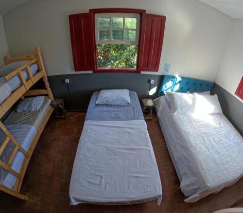 a room with two bunk beds and a window at Nuh Hostel - Quartos coletivos in Ouro Preto