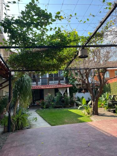 a garden with a pergola in front of a house at Bungalows Teka in Zihuatanejo