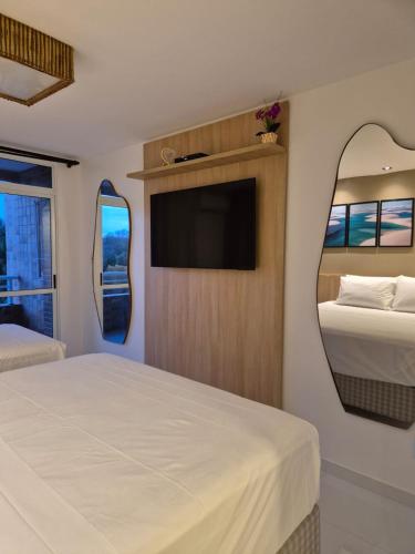 a bedroom with two beds and a flat screen tv at Gran Lençóis Flat Residence Mandacaru 411 in Barreirinhas