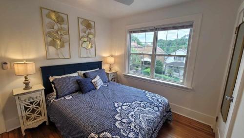 a bedroom with a blue bed and a window at The Brookline Retreat in Pittsburgh