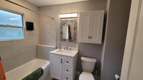 a bathroom with a sink and a toilet and a tub at The Brookline Retreat in Pittsburgh