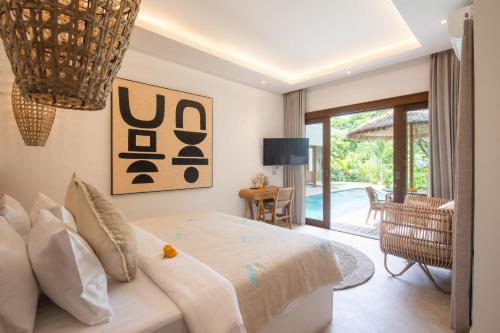 a bedroom with a bed and a view of the pool at Villa Jacelyne - Tropical 2BR Villa with Private Pool in Canggu in Dalung