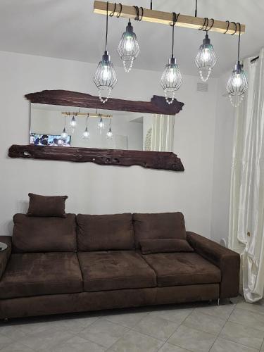a brown couch in a living room with lights at I Tre Mori in Recanati