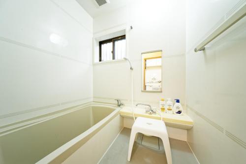 a white bathroom with a sink and a tub at 10 minutes by train to Nagoya Station! Kominka guest house in Nagoya