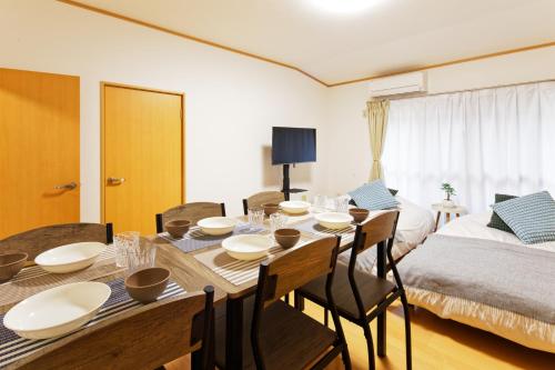 a dining room with a table and chairs and a bed at 10 minutes by train to Nagoya Station! Kominka guest house in Nagoya