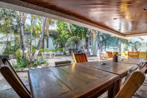 a wooden table and chairs in a patio with trees at Chapalita Grand House in Guadalajara