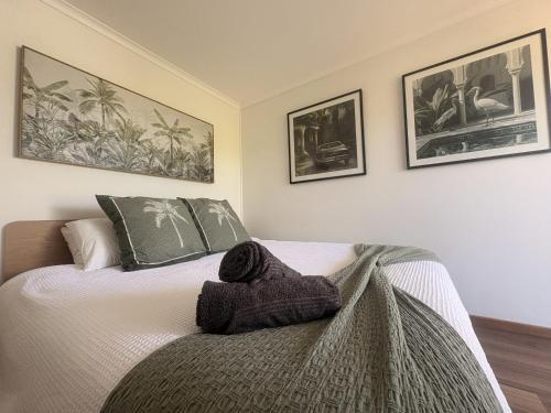 a bedroom with a bed with a blanket on it at Emerald Break- The Perfect Coastal Escape in Emerald Beach