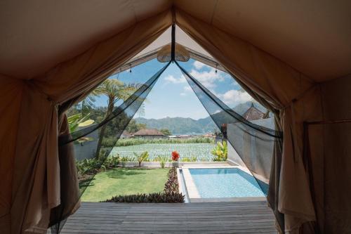 a view from the inside of a tent with a pool at MaHe Glamping in Kubupenlokan