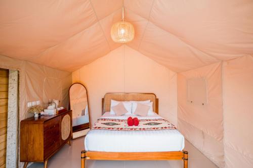 a bedroom with a bed in a tent at MaHe Glamping in Kubupenlokan