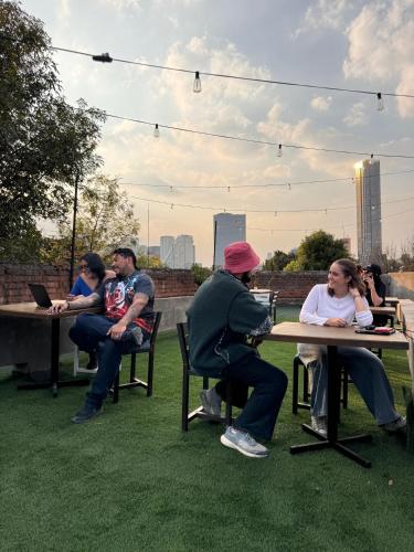 a group of people sitting at tables in a park at Nomaddicts in Mexico City