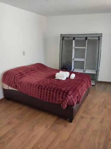 a bedroom with a bed with a red comforter at Suites Casa Blanca Metepec in Toluca