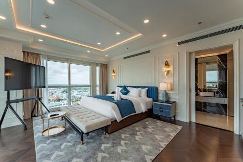 a bedroom with a king sized bed and a television at Cosmo Stars Hotel Bạc Liêu in Bạc Liêu
