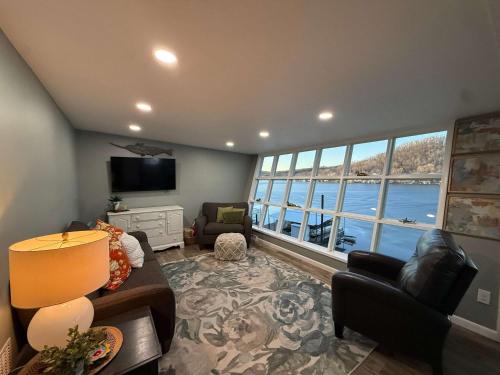 a living room with a couch and a large window at Lucky Duck Lakefront Fire Pit in Gravois Mills