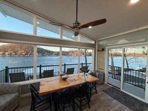 a dining room with a table and some windows at Lucky Duck Lakefront Fire Pit in Gravois Mills