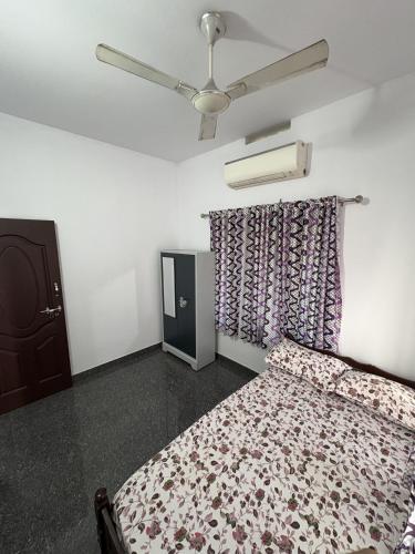 a bedroom with a bed and a ceiling fan at Anchery homes in Trichūr