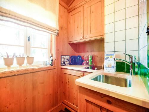 a kitchen with wooden cabinets and a sink and a window at Rustikaler Bauernhof am Ammersee in Pähl