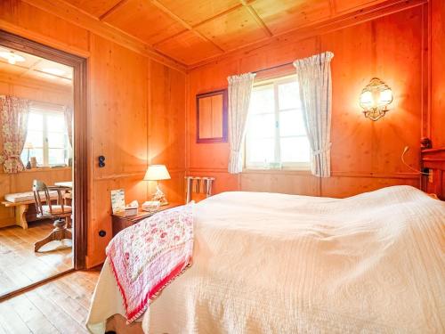 a bedroom with a bed and a desk and a window at Rustikaler Bauernhof am Ammersee in Pähl