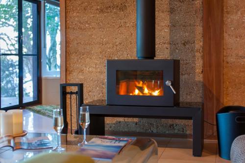 a fireplace in a living room with a table at Eumarella Shores Noosa Lake Retreat in Noosaville