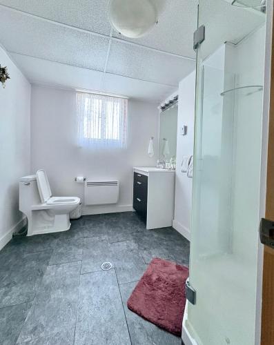 a white bathroom with a toilet and a sink at Bright Private Room near Montreal Fast WiFi in Brossard