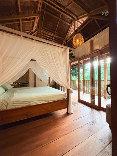 a bedroom with a bed with a mosquito net at The Angkayo in Angkayo