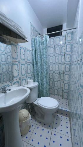 a blue and white bathroom with a toilet and a sink at CATTLEYA Casa Hospedaje in Nueva Cajamarca