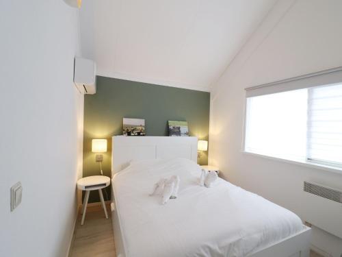 a bedroom with a white bed and a window at Getaway with Bikes & Whirlpool in Grou