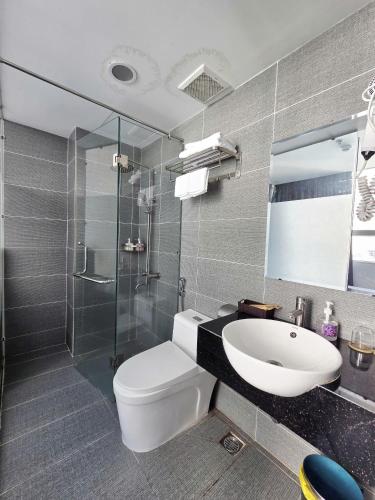 a bathroom with a toilet and a sink and a shower at Moana Hotel Nha Trang in Nha Trang